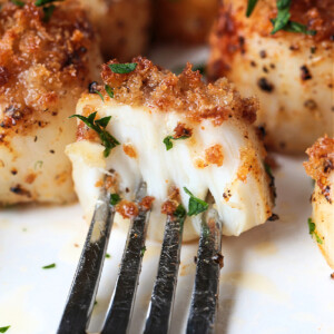 fork holding a scallop cut in half