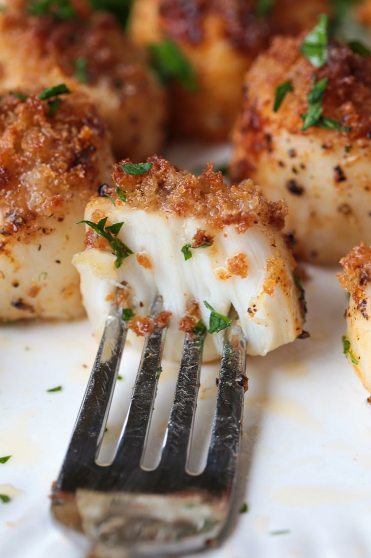 fork holding a scallop cut in half