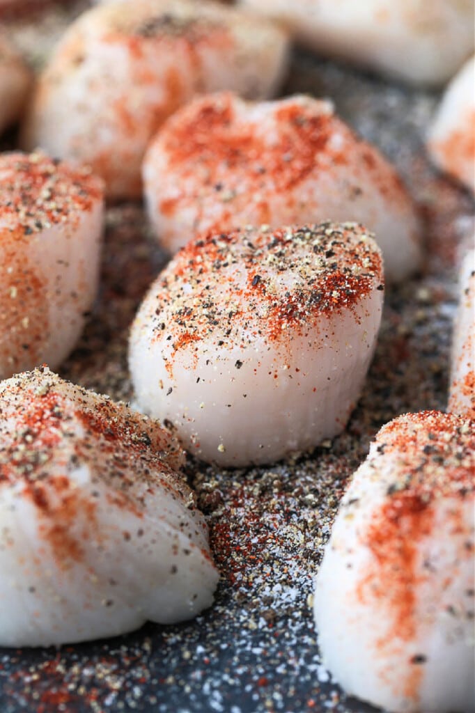 These Air Fryer Scallops are perfectly cooked and are melt in your mouth tender. An easy seafood dinner recipe for any occasion! seasoned scallops on baking sheet