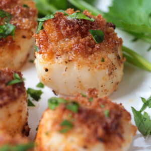 scallops with a breadcrumb crust on plate with parsley