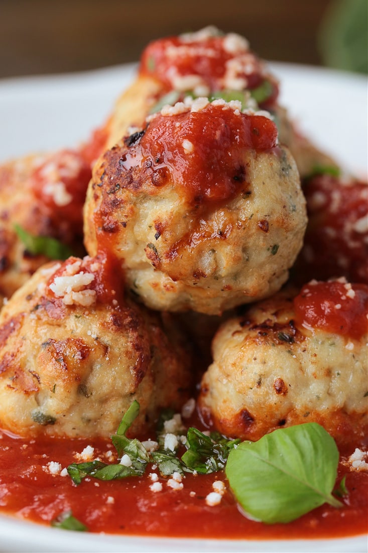 air fryer turkey meatballs on a plate with sauce and basil