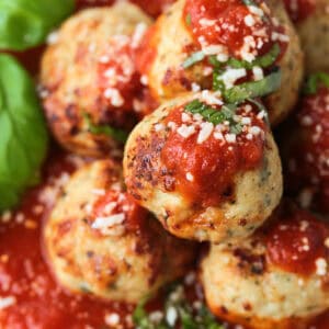 turkey meatballs on a plate with sauce and basil