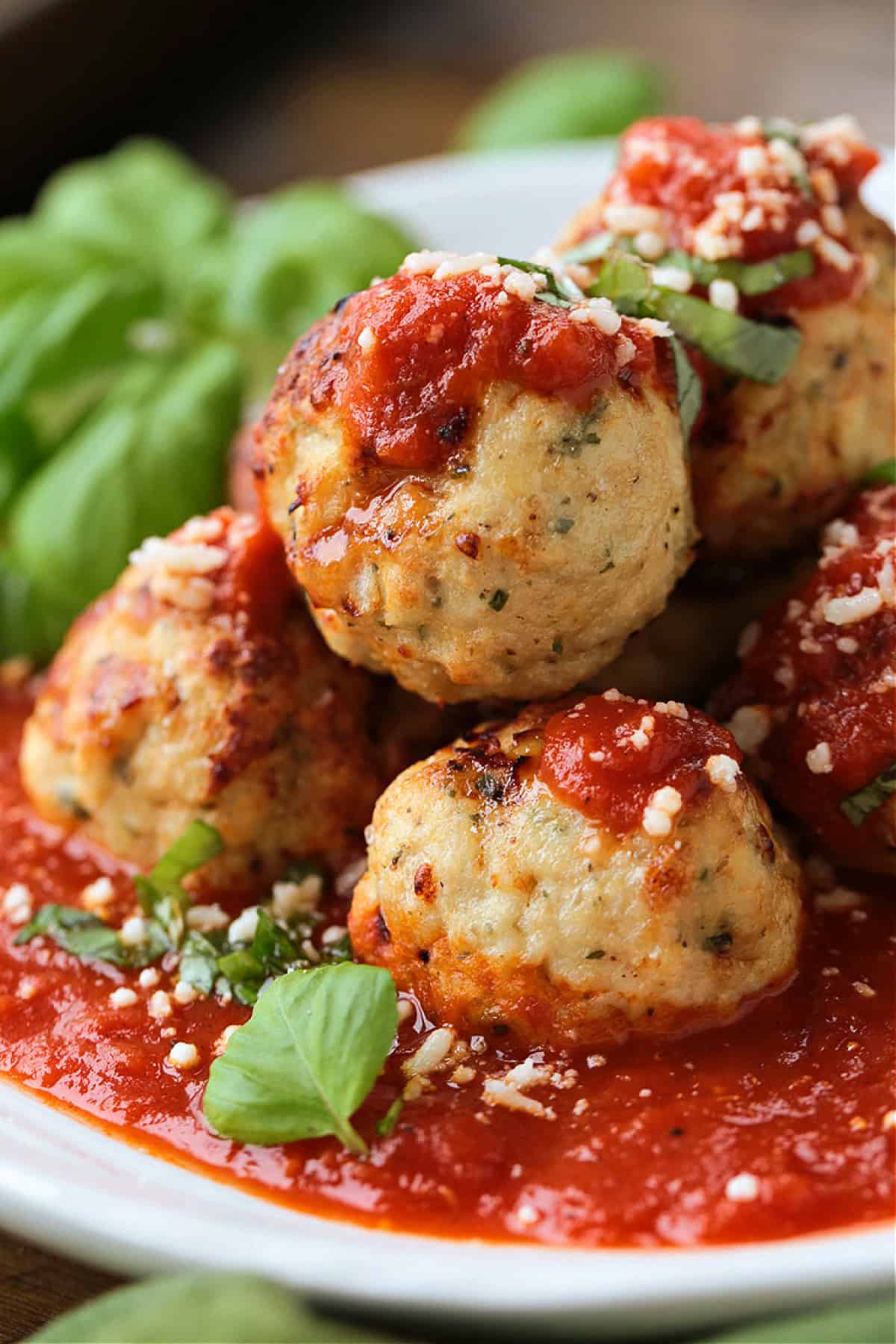 Our Air Fryer Turkey Meatballs are super flavorful and juicy! An easy to make dinner recipe that's ready to serve in just 15 minutes! turkey meatballs stacked on a plate with sauce