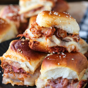 pulled pork sliders stacked on a plate