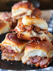 pulled pork sliders stacked on a plate