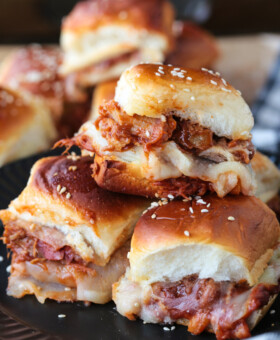 pulled pork sliders stacked on a plate