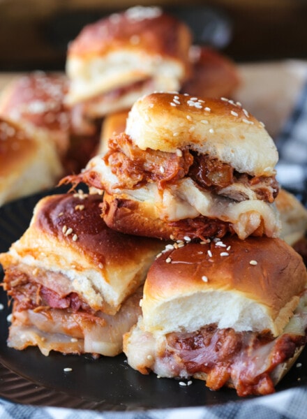 pulled pork sliders stacked on a plate