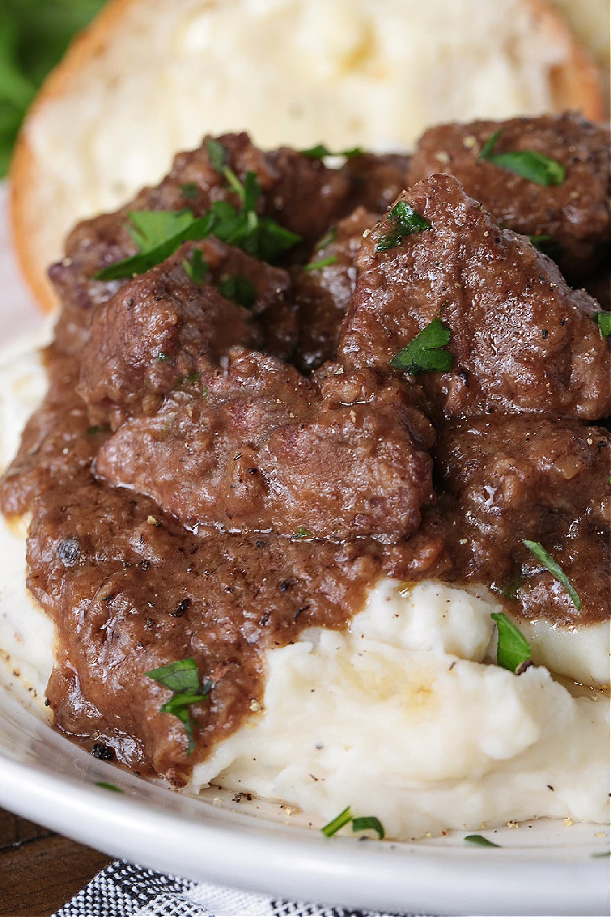 slow cooker beef tips with gravy on a bed of mashed potatoes