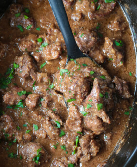 slow cooker beef tips with black spoon