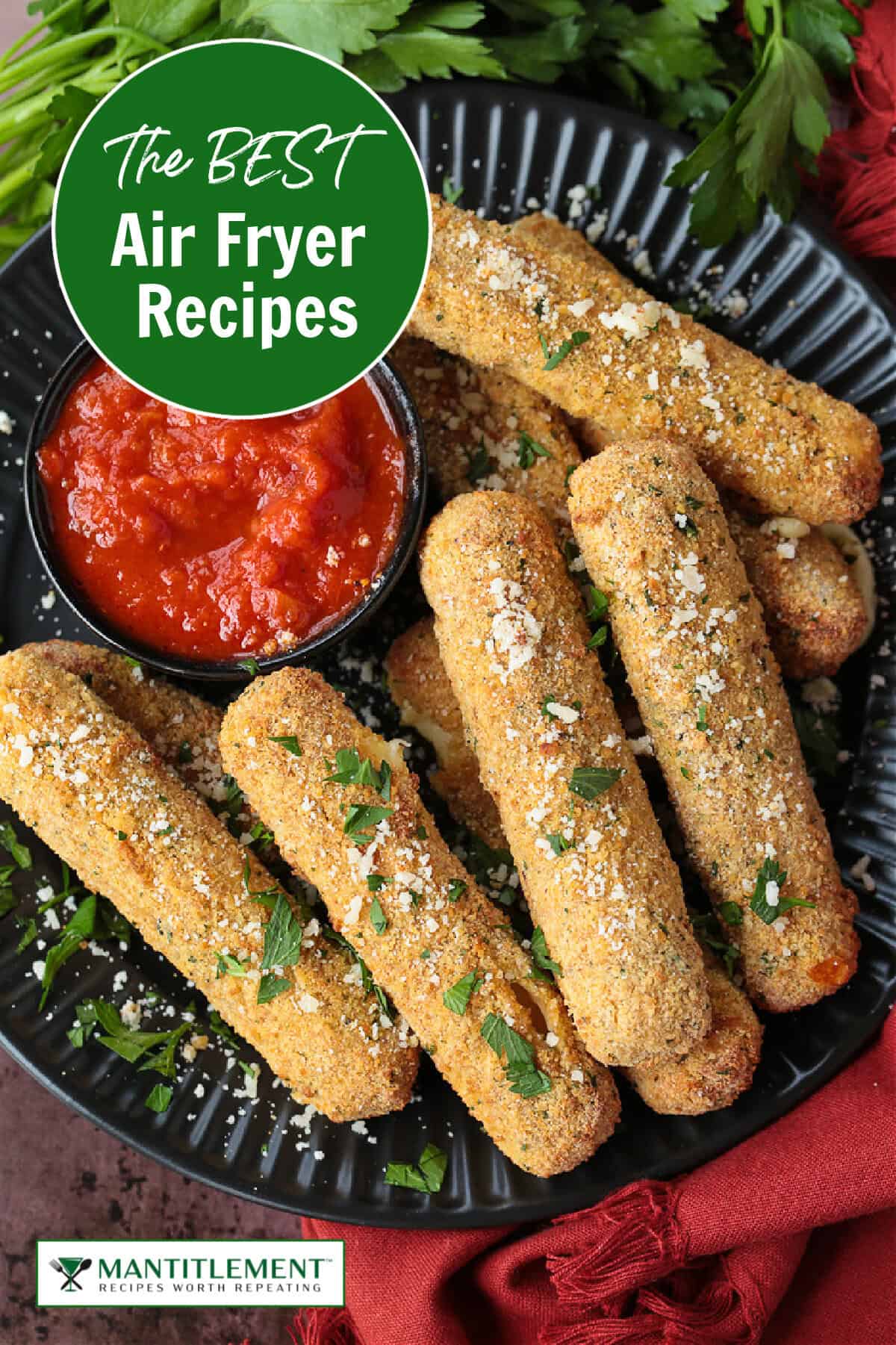 air fryer mozzarella sticks on black plate with sauce