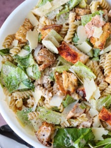 chicken caesar pasta salad in bowl with spoon