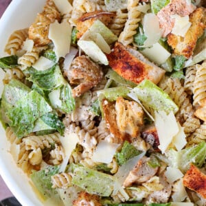 chicken caesar pasta salad in bowl with spoon