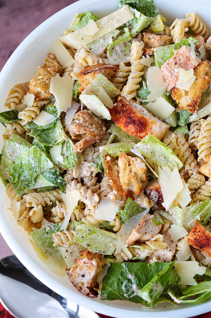 chicken caesar pasta salad in bowl with spoon