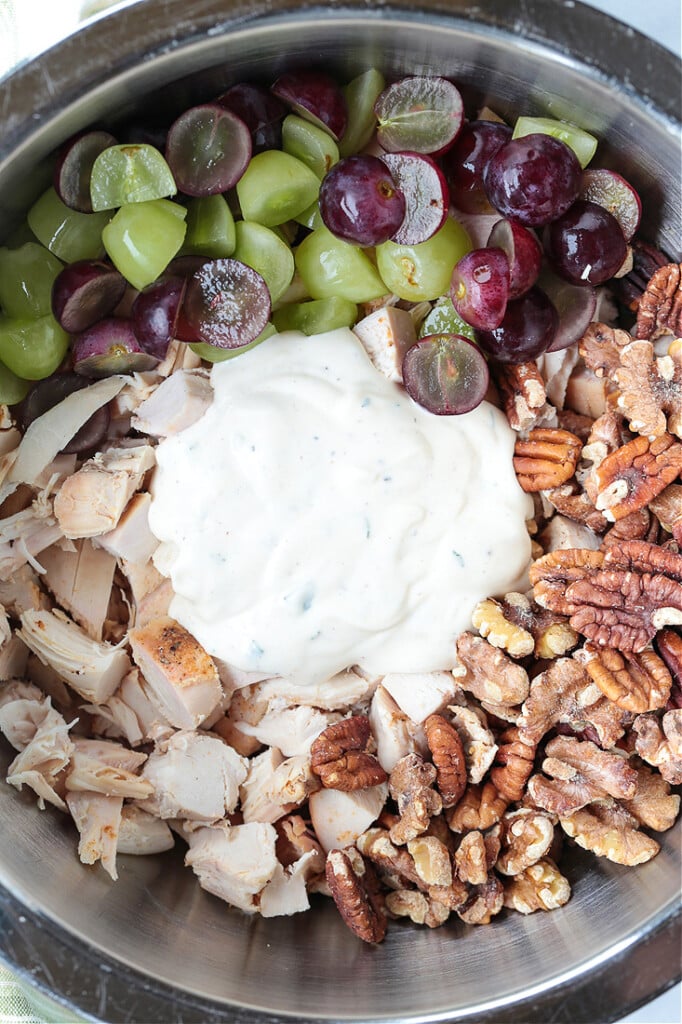 This creamy and crunchy Chicken Salad with Grapes and Walnuts hits all the flavor notes. Spoon onto a bed of lettuce or scoop on a sandwich! ingredients for chicken salad recipe in a bowl