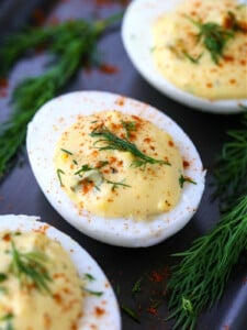 deviled eggs on a platter with fresh dill on top