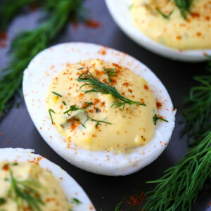 deviled eggs on a platter with fresh dill on top