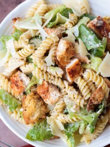 pasta salad with lettuce and chicken on a white plate