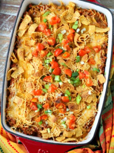 Frito Pie casserole on a wood board with napkin