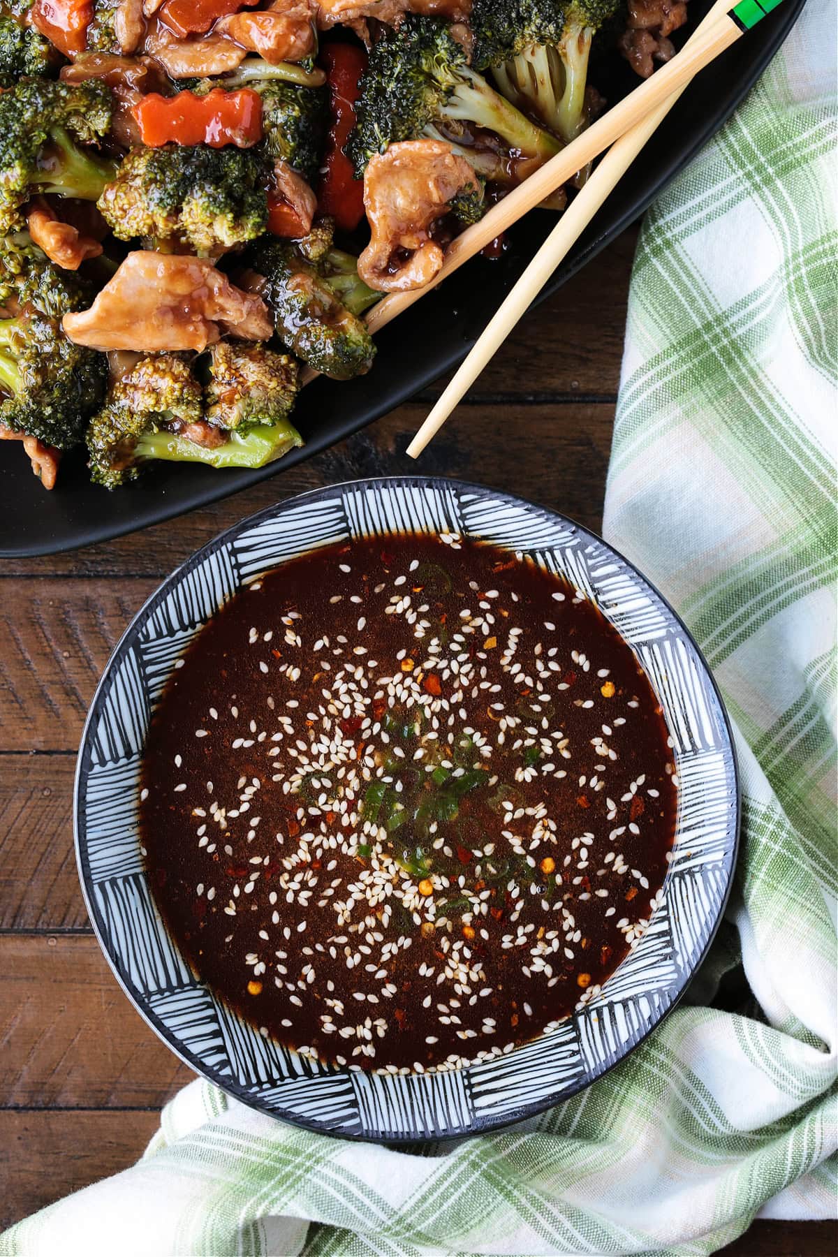 homemade stir fry sauce in a bowl with napkin and chicken and broccoli in background