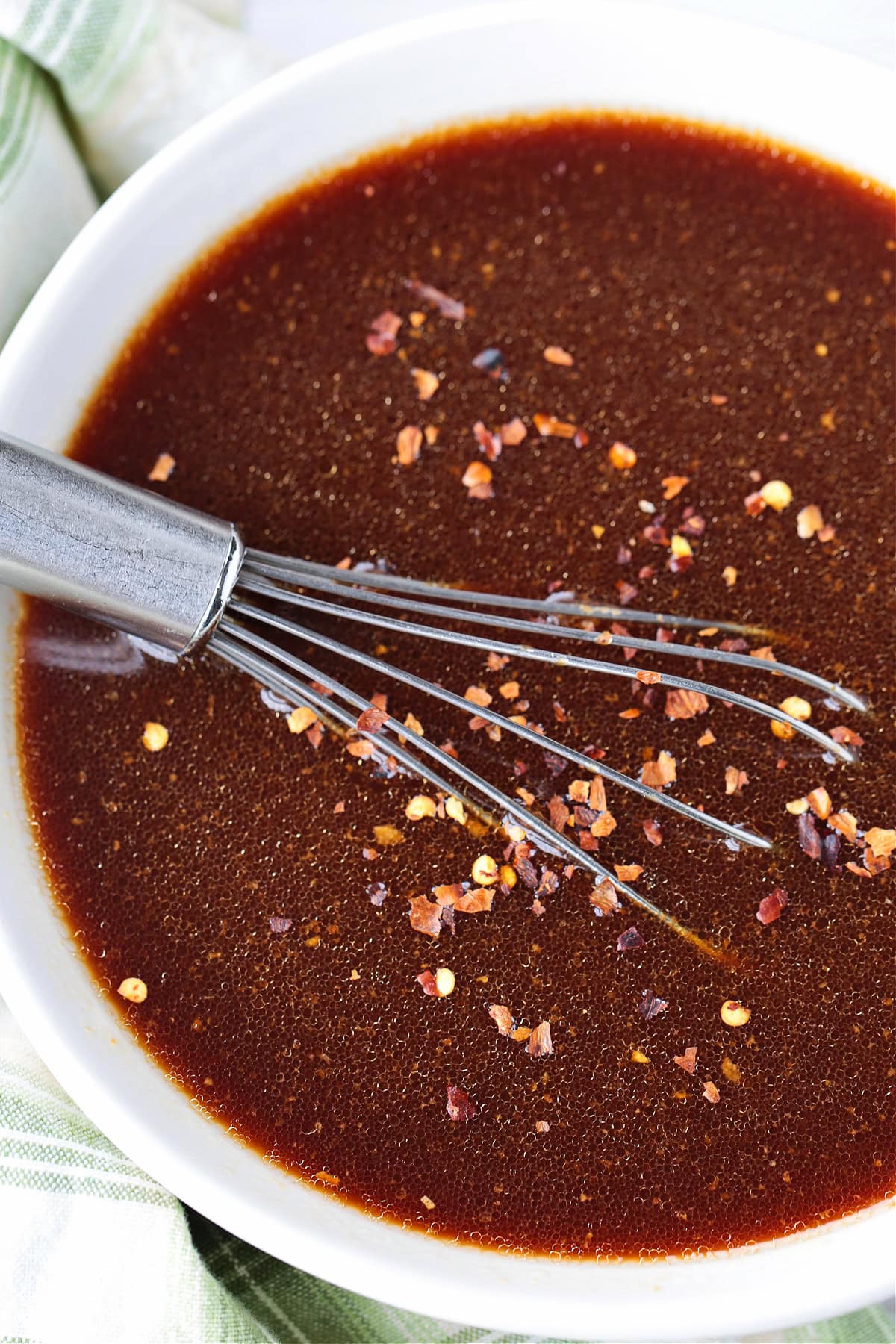 whisk in white bowl with stir fry sauce