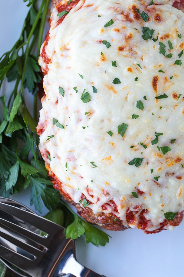 meatloaf topped with sauce and cheese on platter