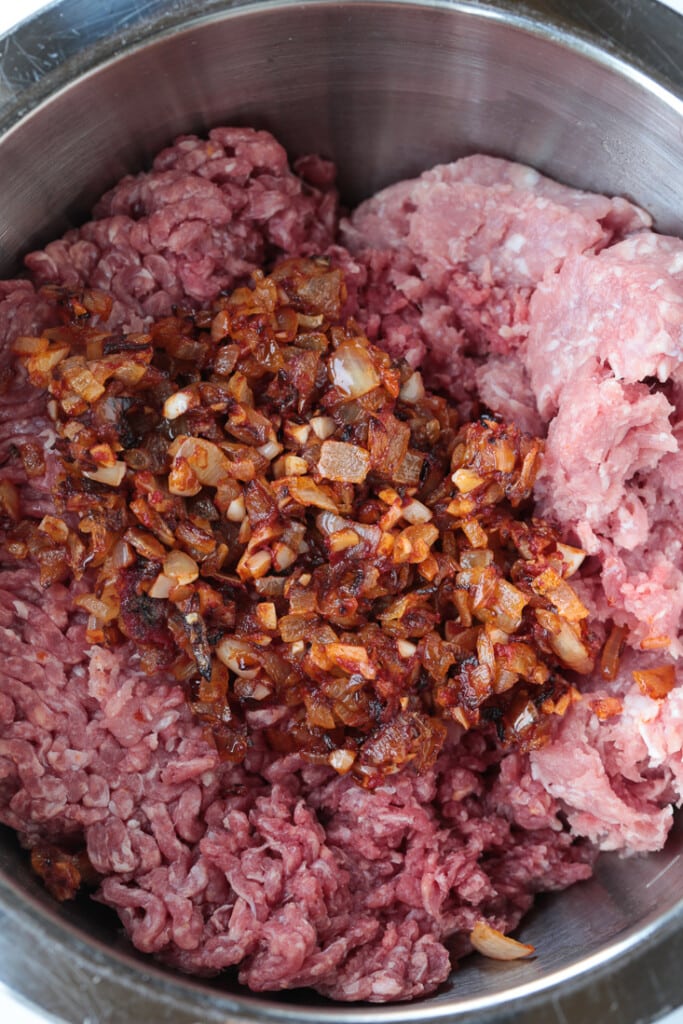 ground beef and ground pork in a bowl with onions