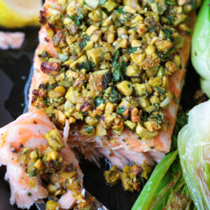 fork with a bite of salmon on black platter