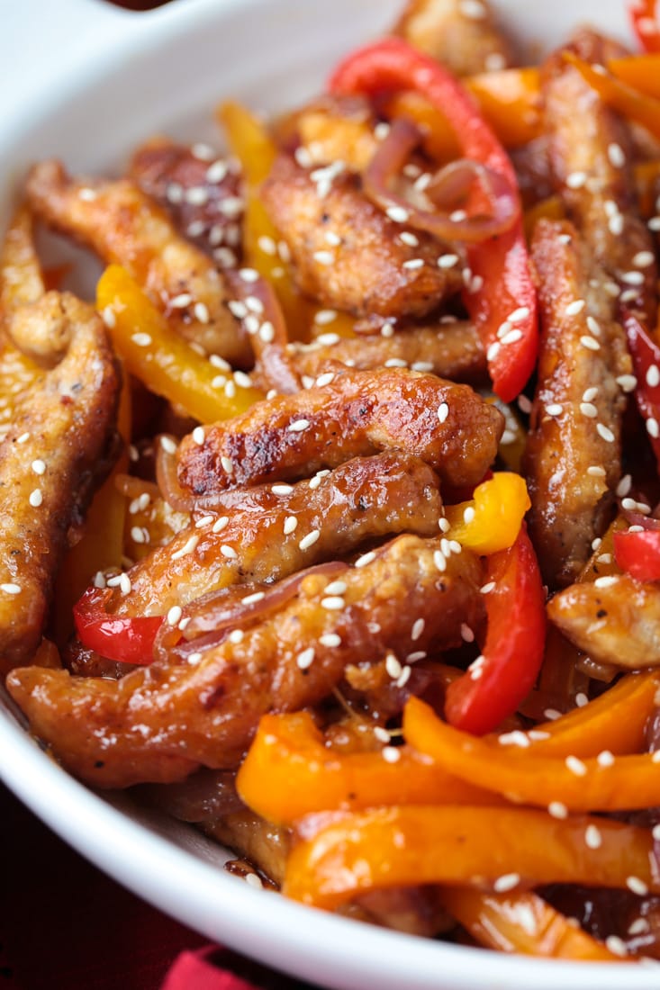 Our Pork Stir Fry Recipe is perfect for weeknight meals. Crispy, tender pork with crunchy vegetables and our famous stir fry sauce. pork stir fry in a white bowl