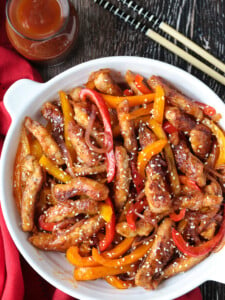 pork stir fry in a bowl with sauce and chop sticks