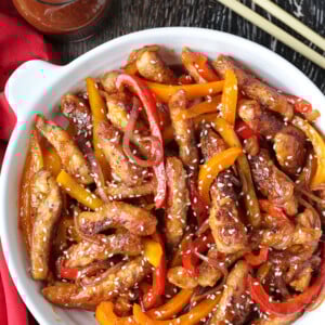 pork stir fry in a bowl with sauce and chop sticks