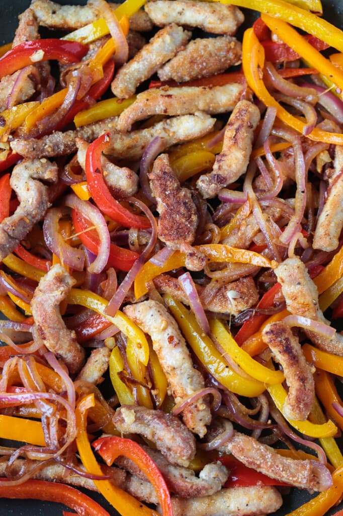 strips of pork and vegetables in a wok