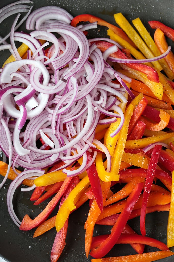 red onions and peppers in a wok