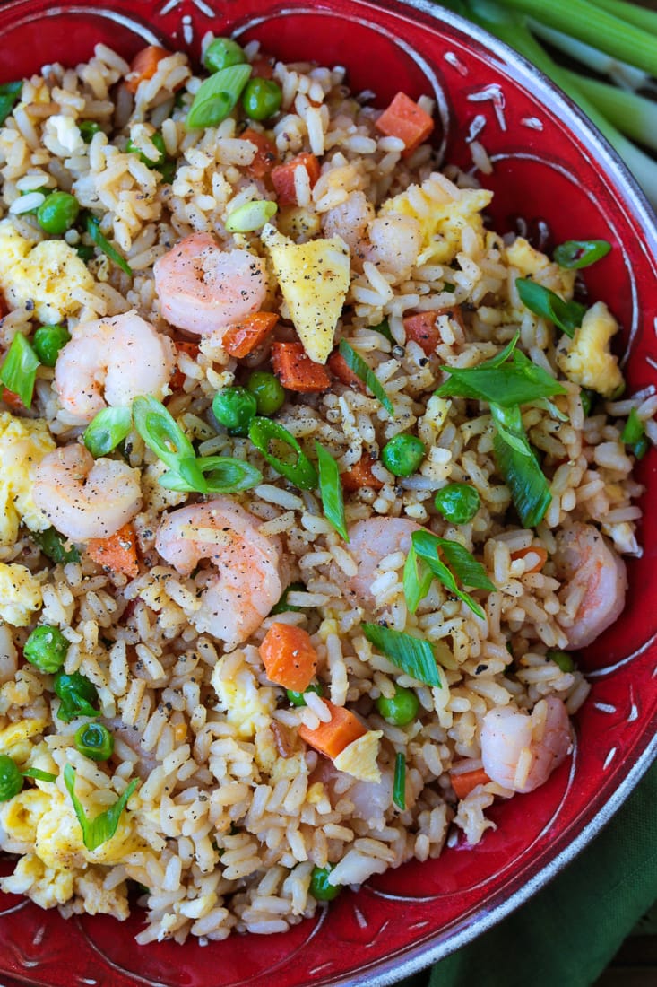 Shrimp Fried Rice is a classic Asian dish that's easy to make at home! A fun and healthy dinner that can be customized to your liking! fried rice with shrimp in a red bowl with scallions for garnish