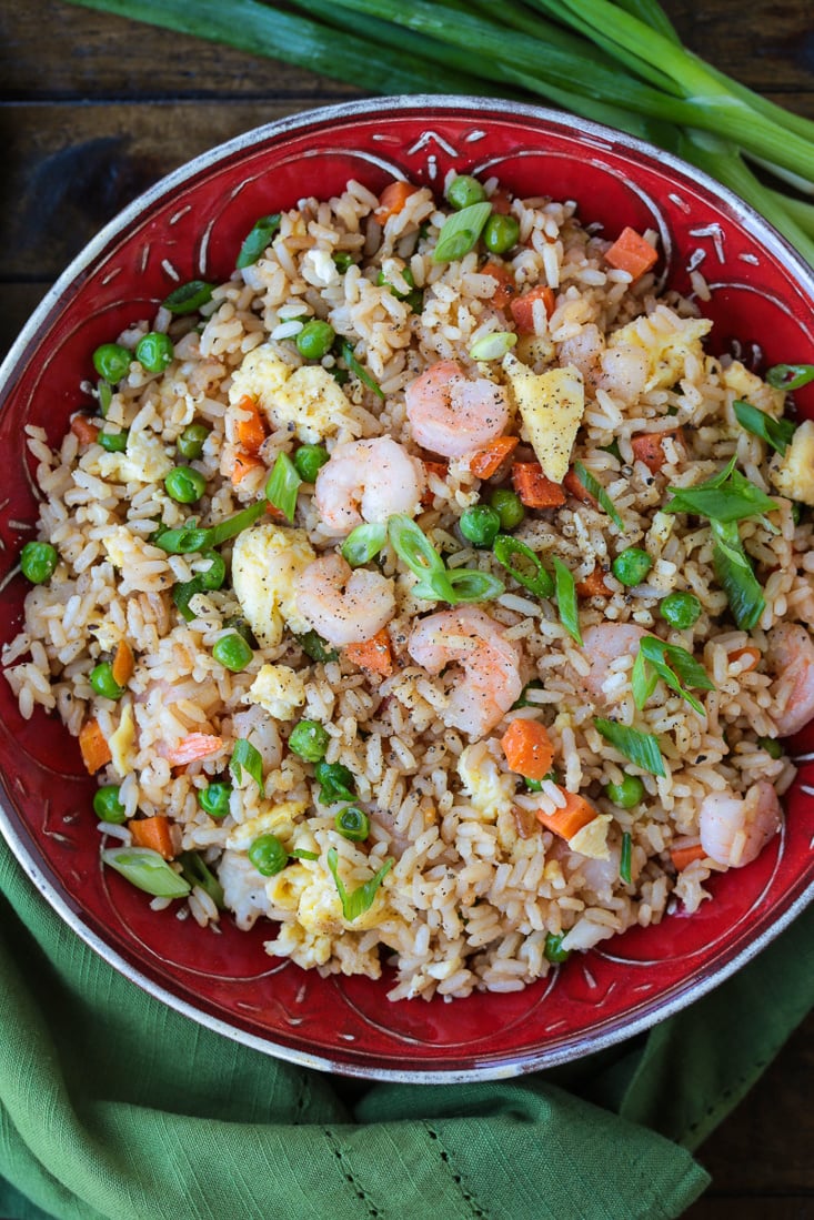 Shrimp Fried Rice is a classic Asian dish that's easy to make at home! A fun and healthy dinner that can be customized to your liking! shrimp fried rice in red bowl with scallions
