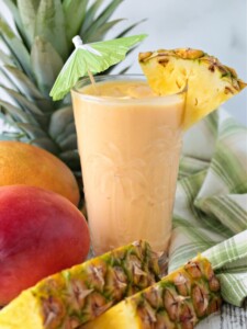 mango pineapple smoothie in glass with umbrella