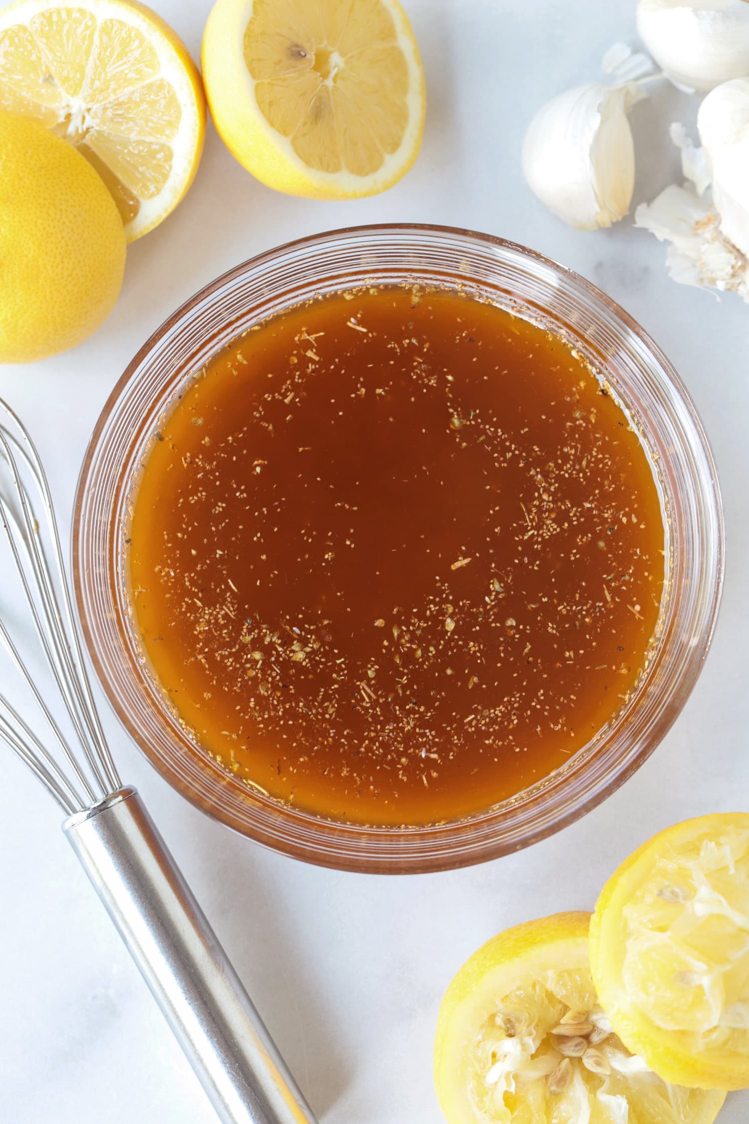 greek chicken marinade in a bowl with lemons and garlic