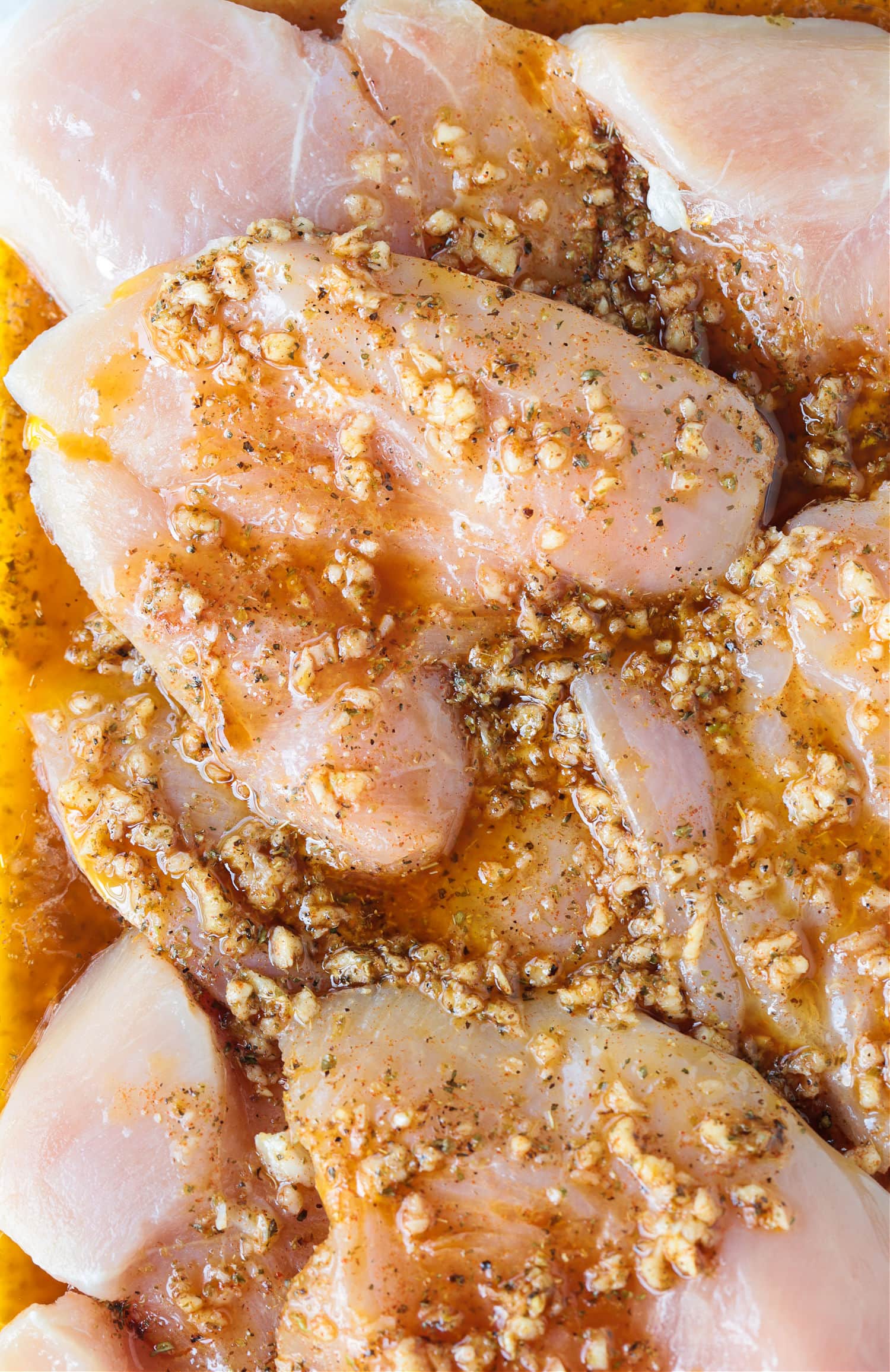 Chicken breasts marinating in a greek marinade