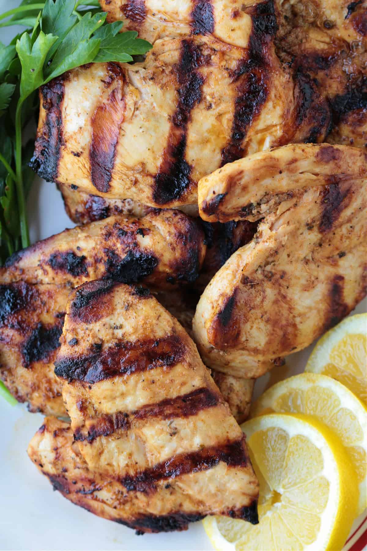 This Greek Chicken Marinade is super versatile! Lemon juice, garlic and oregano come together to make the most juicy, flavorful chicken. grilled chicken breasts with lemons and parsley