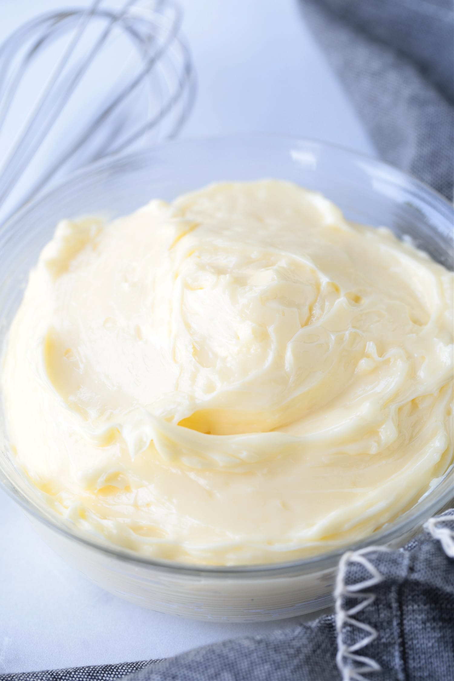 homemade mayonnaise is a glass bowl with napkin and whisk