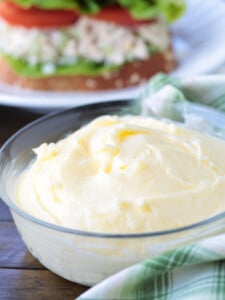 homemade mayonnaise in a bowl in front of sandwich