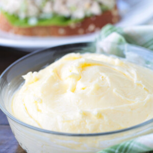 homemade mayonnaise in a bowl in front of sandwich