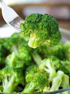 broccoli floret on fork over bowl of broccoli