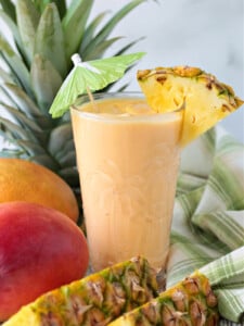 mango pineapple smoothie in glass with umbrella