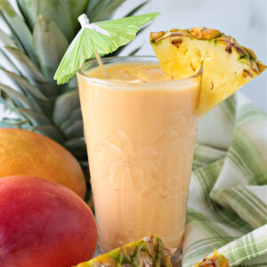 mango pineapple smoothie in glass with umbrella