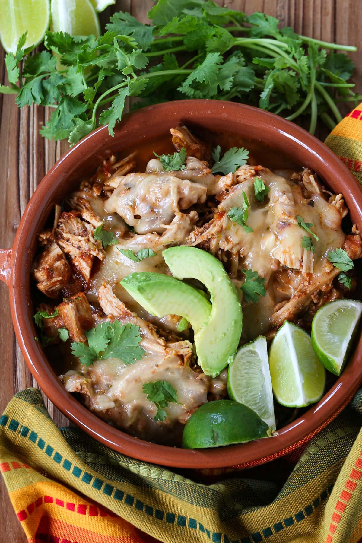 Slow Cooker Taco Chicken is so easy to make. Use it in tacos, rice bowls or on nachos! A slow cooker chicken recipe that everyone loves. taco chicken in a bowl with cheese and avocado