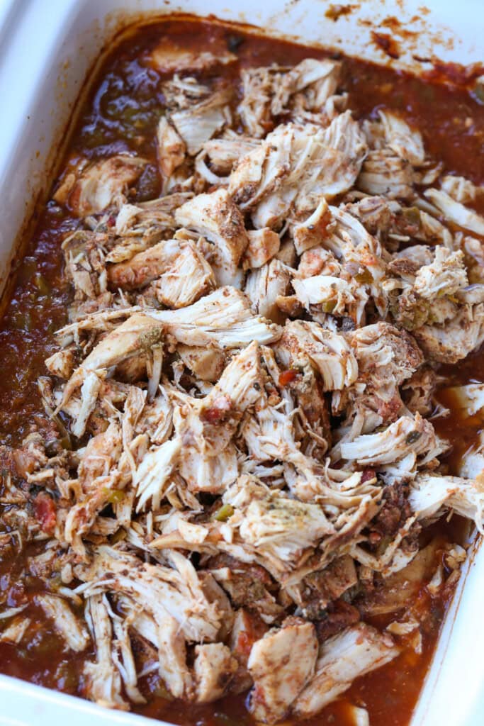 Slow Cooker Taco Chicken is so easy to make. Use it in tacos, rice bowls or on nachos! A slow cooker chicken recipe that everyone loves. shredded chicken in a slow cooker with sauce