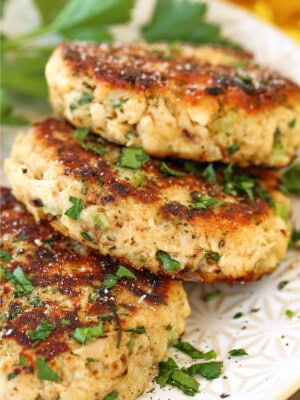 tuna cakes stacked on plate with parsley
