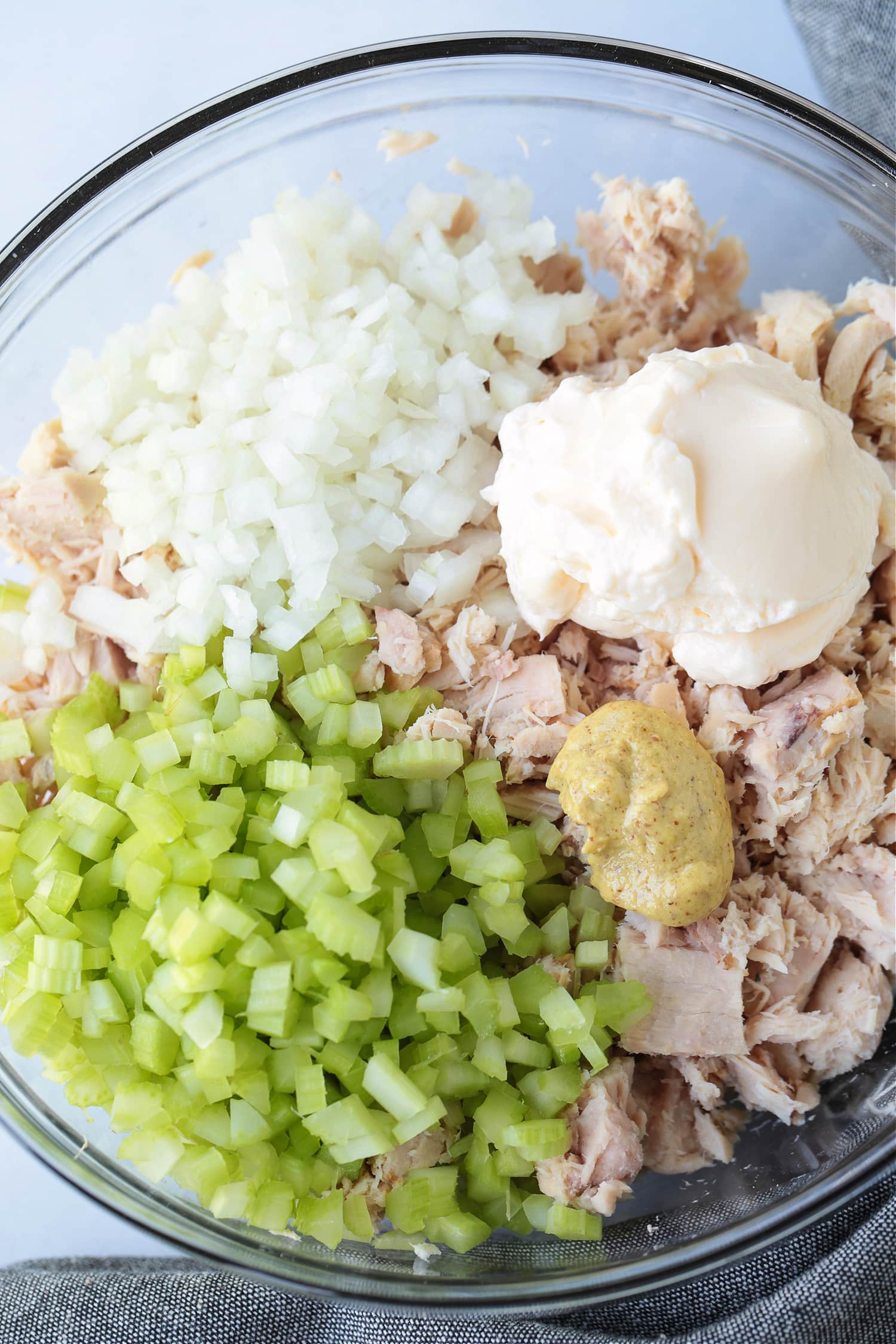 What can be more satisfying than a perfect Tuna Salad Sandwich Recipe? Add on the toppings that you like, piled on bread or a roll for lunch or a light dinner! ingredients in a bowl for making tuna fish salad