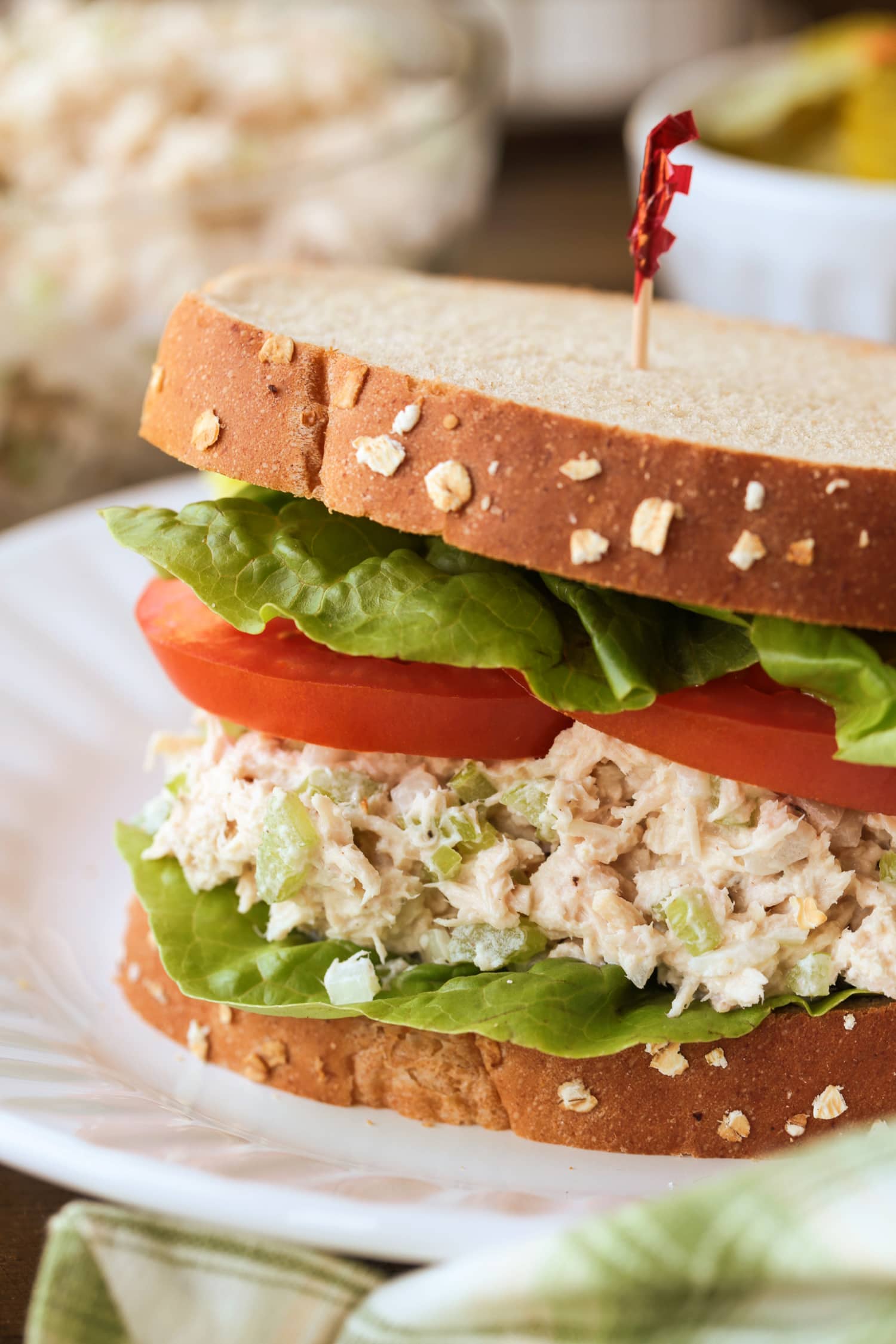 What can be more satisfying than a perfect Tuna Salad Sandwich Recipe? Add on the toppings that you like, piled on bread or a roll for lunch or a light dinner! tuna salad sandwich on a plate with toothpick