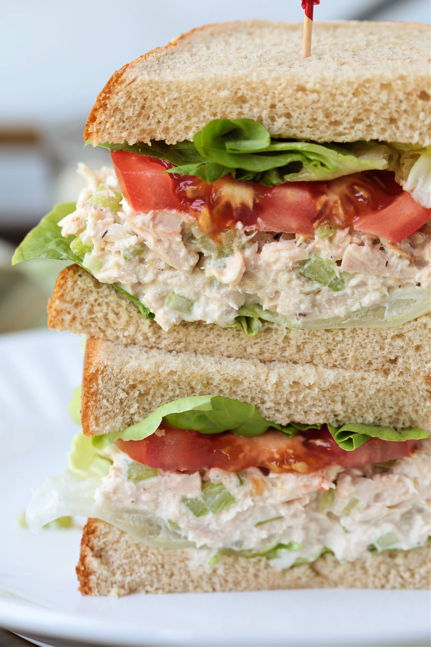 tuna salad sandwich sliced and stacked on a plate up close